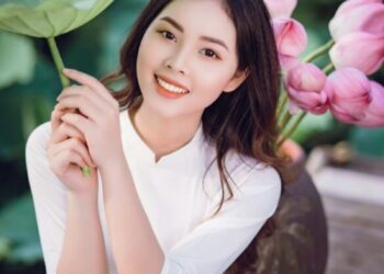 cô gái giơ lá sen len che đầu